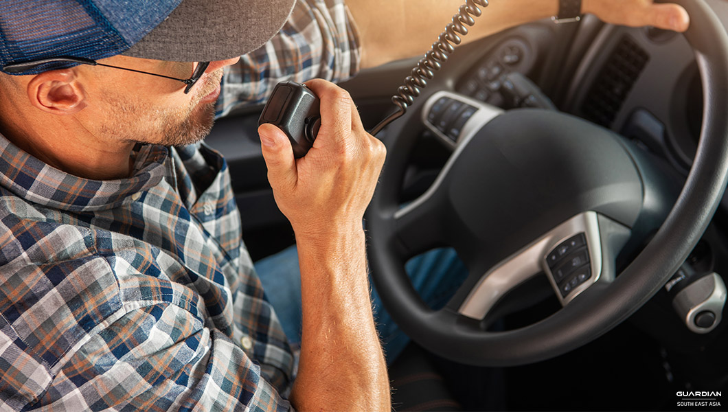 man in car using walkie-talkie